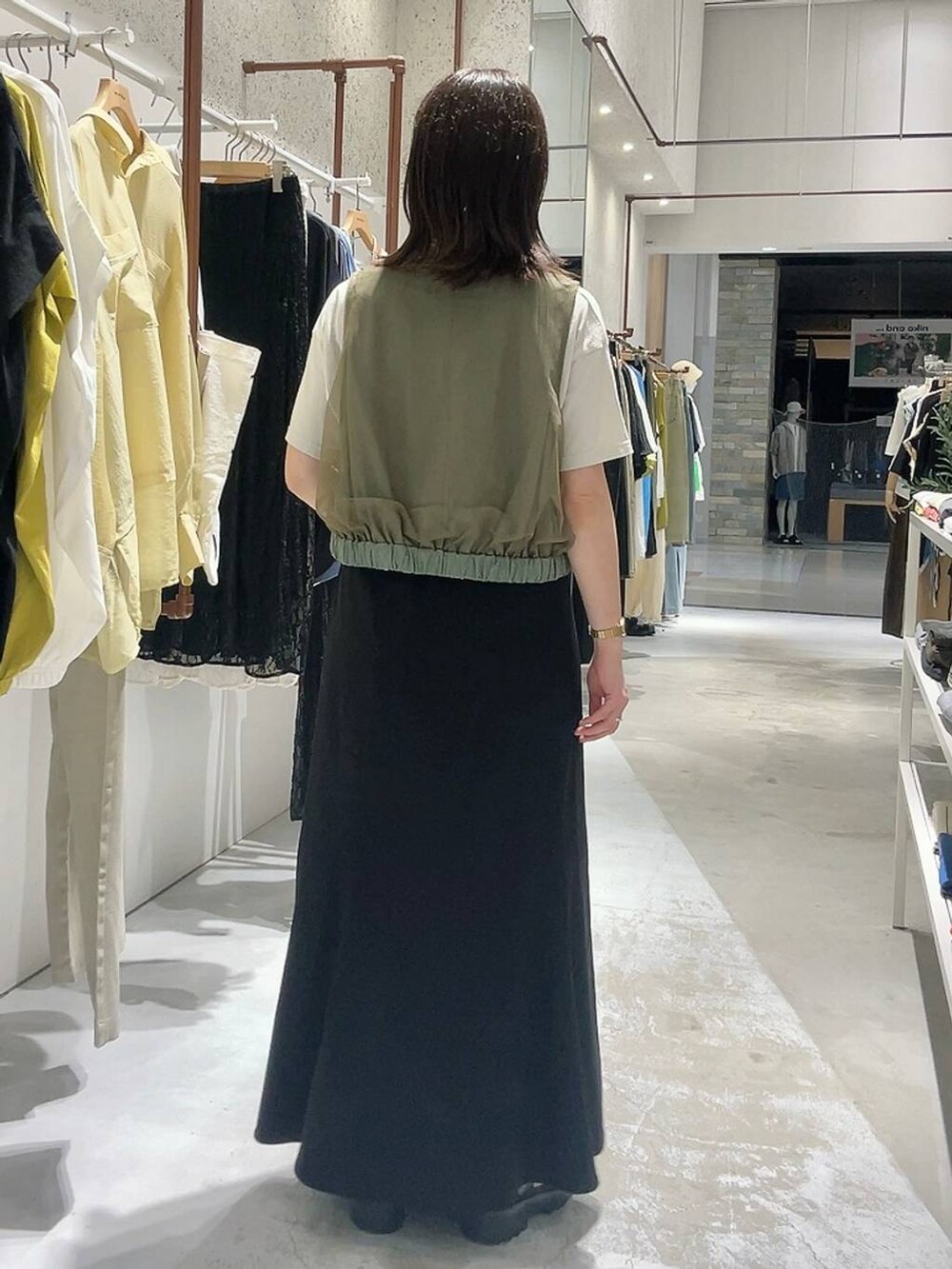 グリーン系のその他アウター、ホワイト系のトートバッグ、ブラウン系のサンダルを着用したレディースの夏コーディネートの6枚目の写真