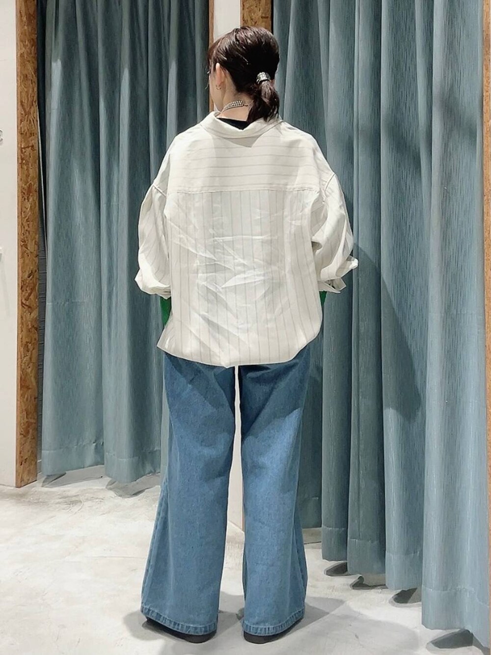 ブルー系のスニーカー、ブラック系のTシャツ/カットソー、ブルー系のデニムパンツを着用したレディースの冬コーディネートの3枚目の写真