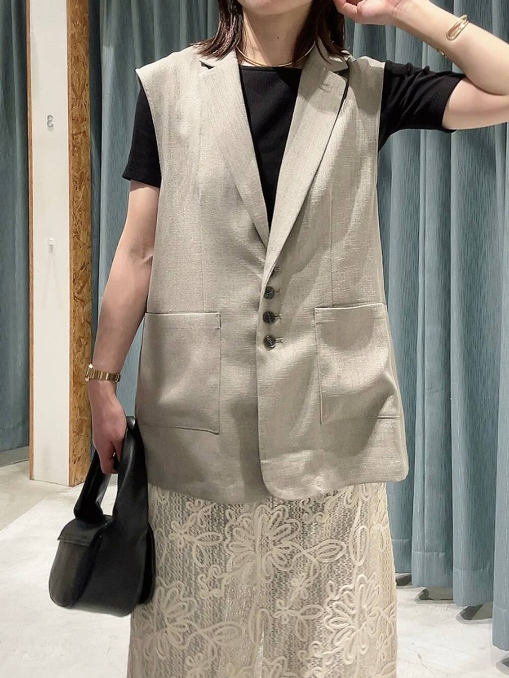 ブラック系のTシャツ/カットソー、ブラック系のハンドバッグ、ブラウン系のサンダルを着用したレディースの春コーディネートの2枚目の写真