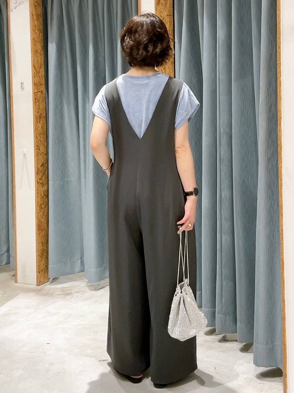 シルバー系のショルダーバッグ、ブラック系のサンダル、グレー系のサロペット/オーバーオールを着用したレディースの夏コーディネートの3枚目の写真