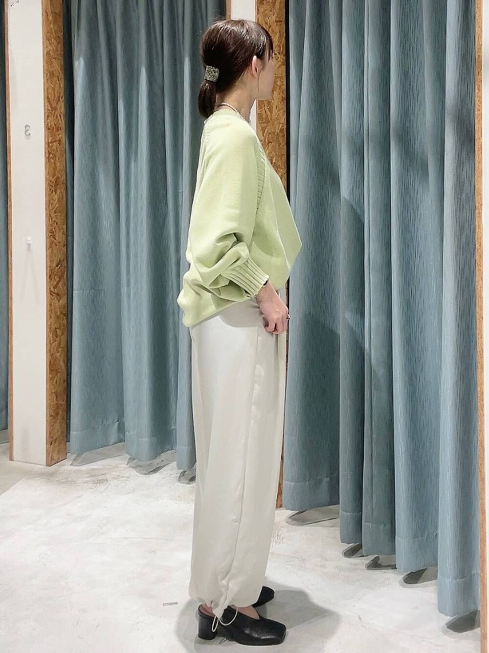 ホワイト系のその他パンツ、ブラック系のパンプス、グリーン系のニット/セーターを着用したレディースの冬コーディネートの2枚目の写真