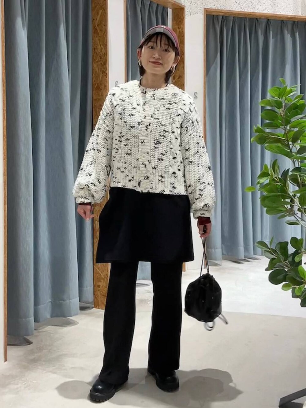 ブラック系のショルダーバッグ、ブラック系のその他パンツ、ホワイト系のニット/セーターを着用したレディースの秋コーディネートの2枚目の写真