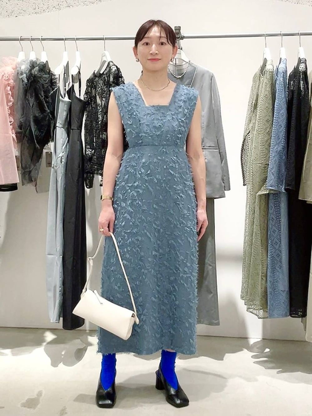 ホワイト系のショルダーバッグ、ブラック系のパンプス、ブラック系のキャミソールを着用したレディースの春コーディネートの7枚目の写真