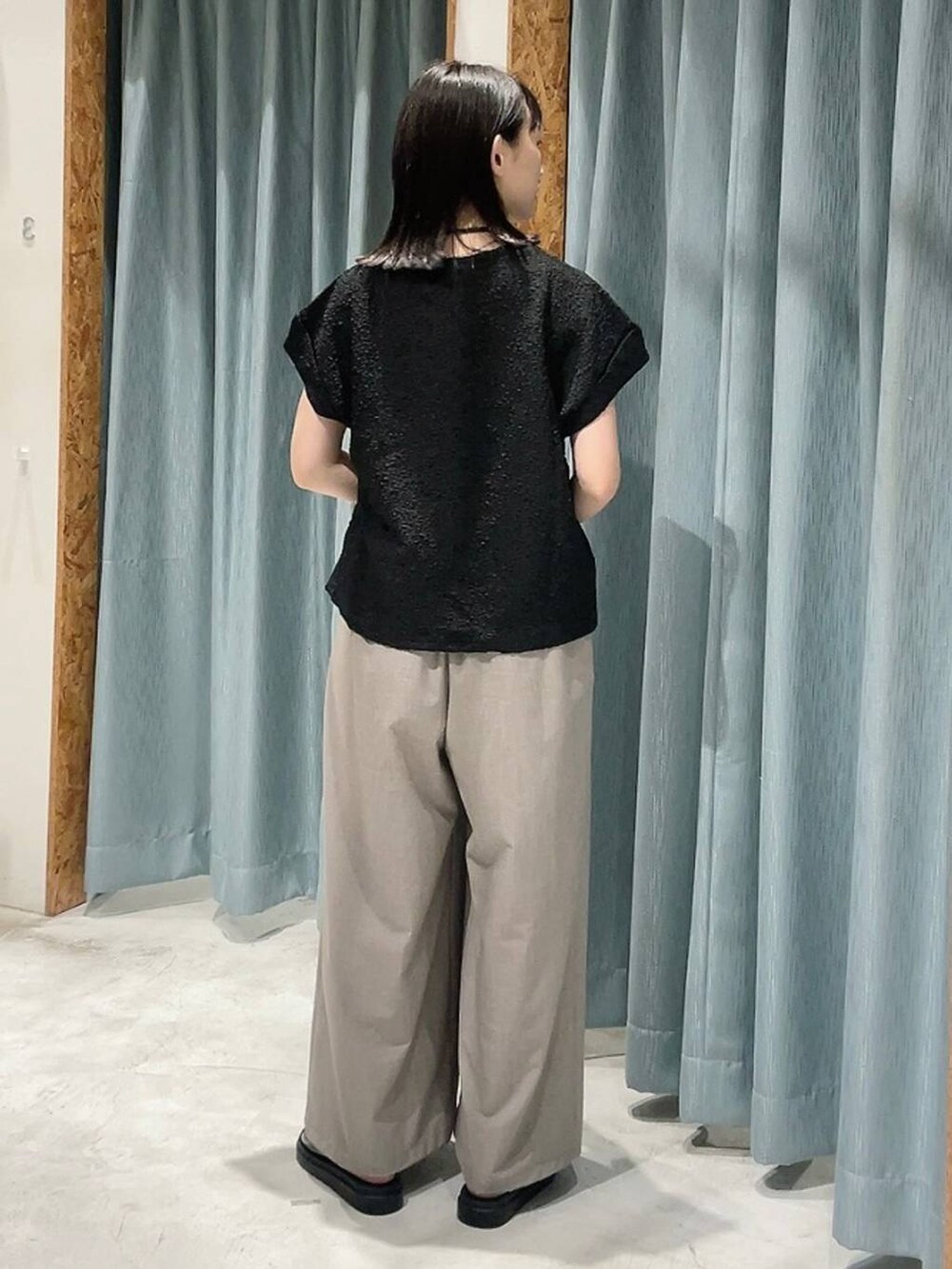 ブラウン系のサンダル、ベージュ系のその他パンツ、ブラック系のTシャツ/カットソーを着用したレディースの夏コーディネートの5枚目の写真