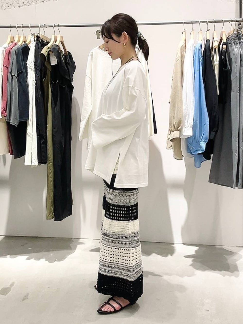 ホワイト系のTシャツ/カットソー、ブラック系のスカート、ブラック系のショルダーバッグを着用したレディースの春コーディネートの5枚目の写真
