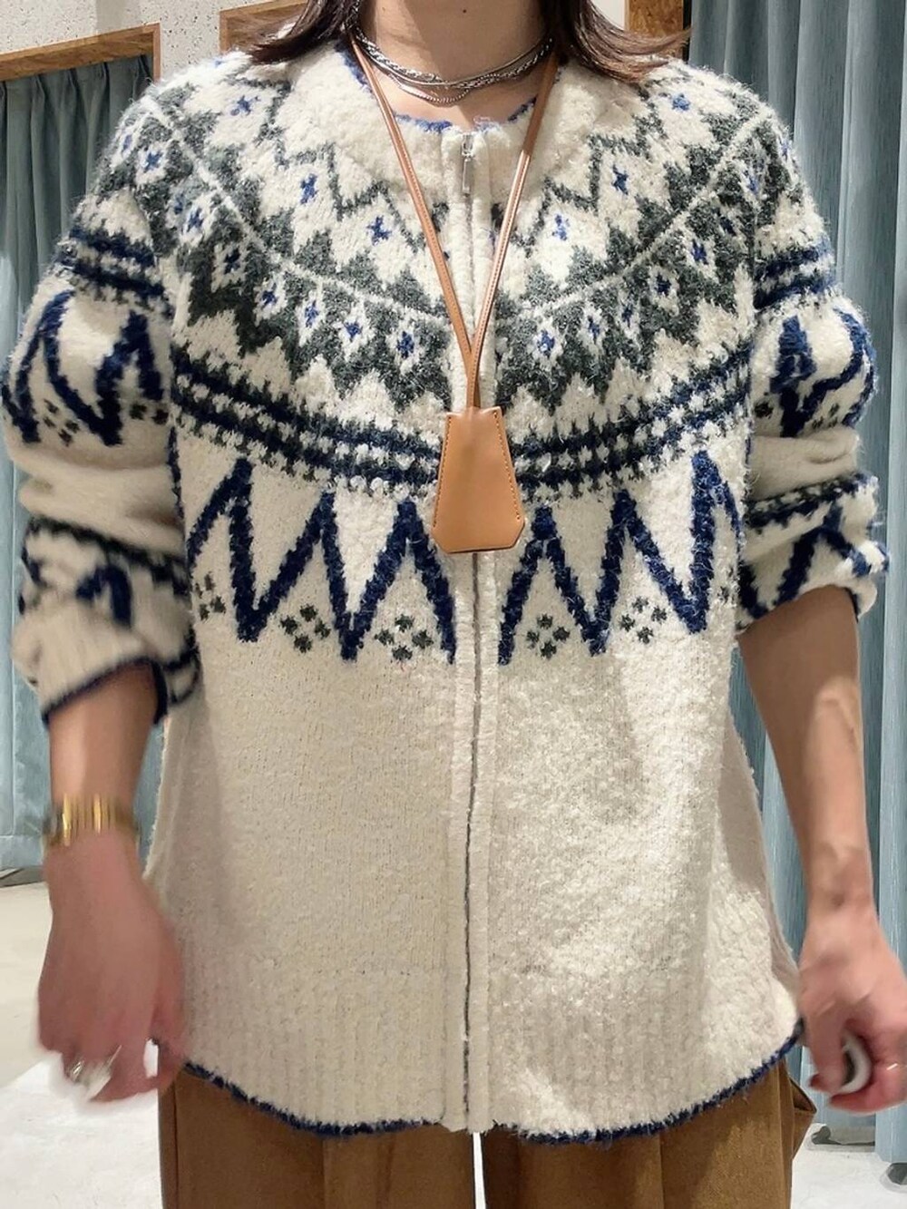 ブルー系のスニーカー、ホワイト系のカーディガン/ボレロ、ブルー系のキャップを着用したレディースの秋コーディネートの2枚目の写真