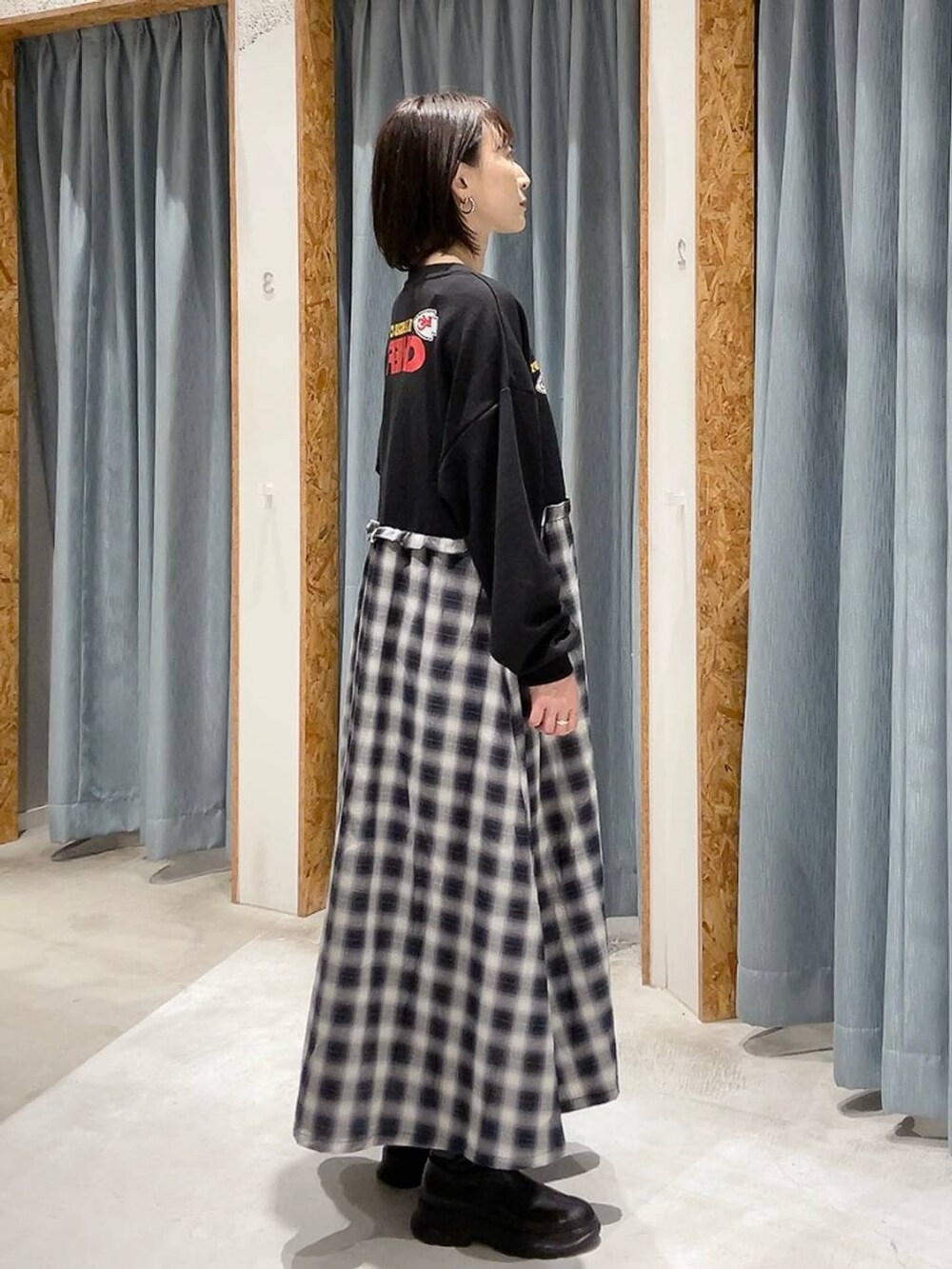 ブラック系のブーツ、ブラック系のワンピースを着用したレディースの秋コーディネートの2枚目の写真