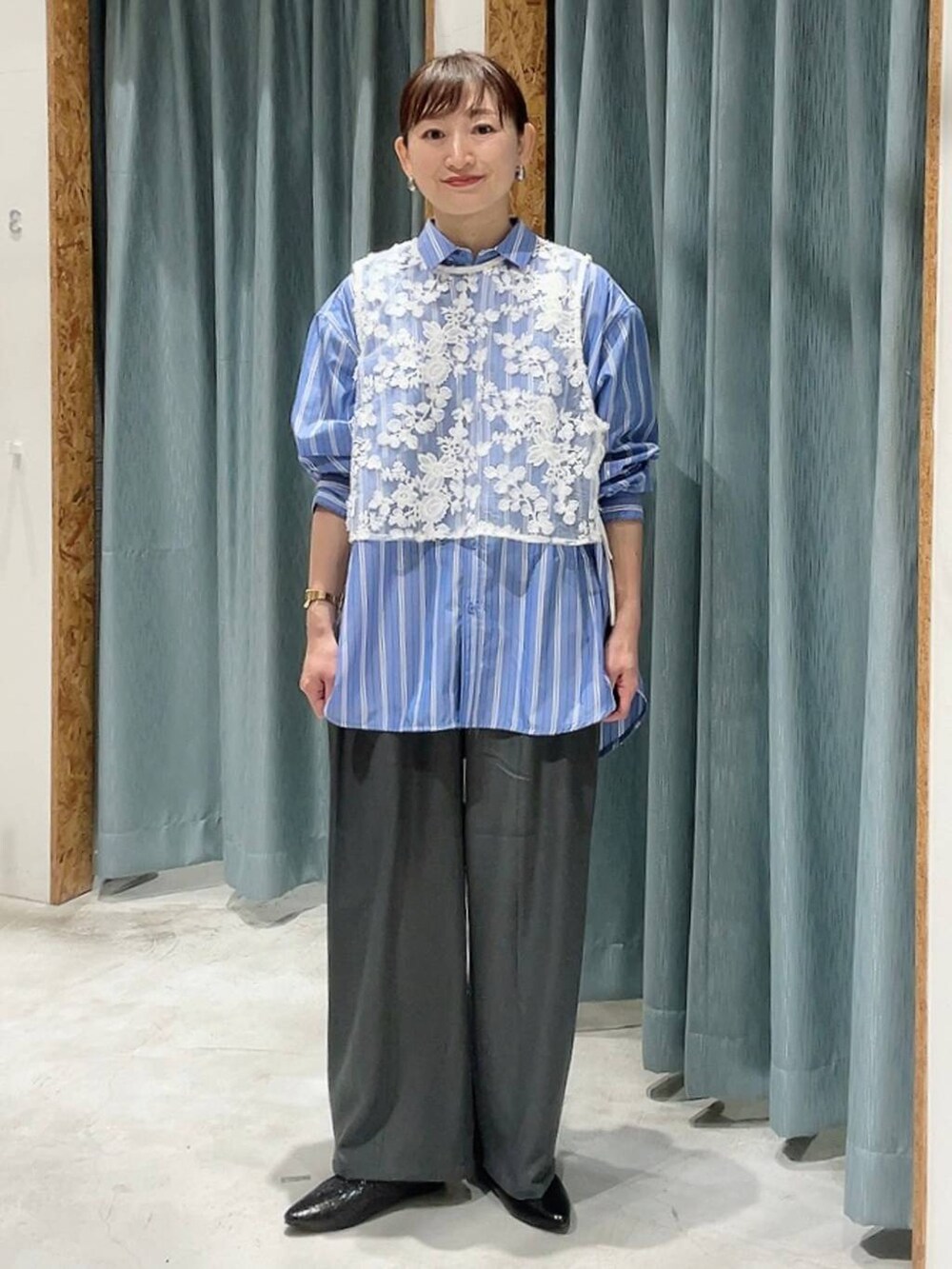 グレー系のその他パンツ、ブラック系のパンプス、ブルー系のシャツ/ブラウスを着用したレディースの冬コーディネートの6枚目の写真