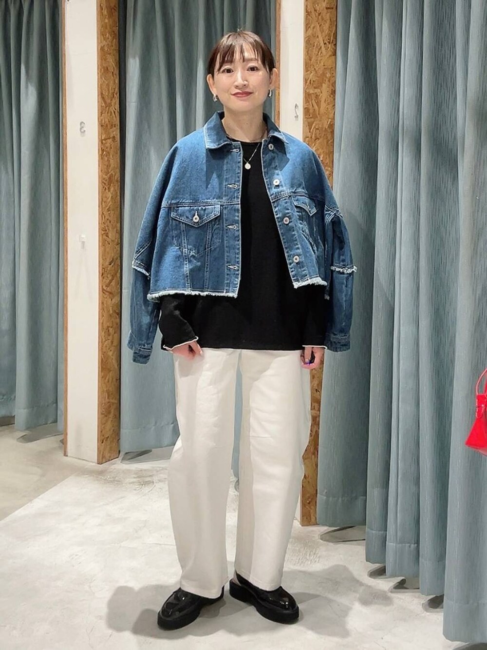 ホワイト系のデニムパンツ、ブラック系のローファー、ブルー系のデニムジャケットを着用したレディースの冬コーディネートの6枚目の写真