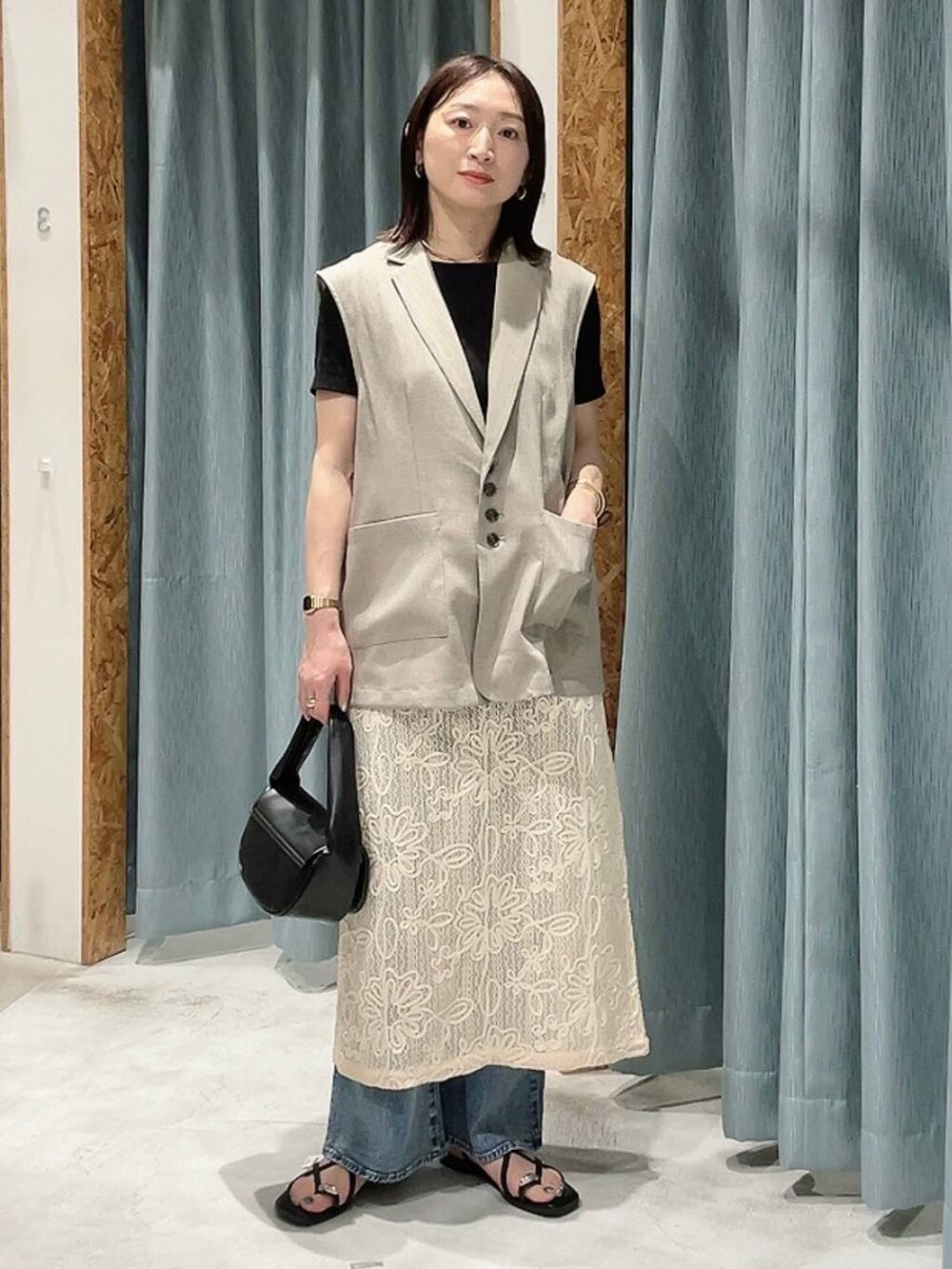 ブラック系のTシャツ/カットソー、ブラック系のハンドバッグ、ブラウン系のサンダルを着用したレディースの春コーディネートの7枚目の写真