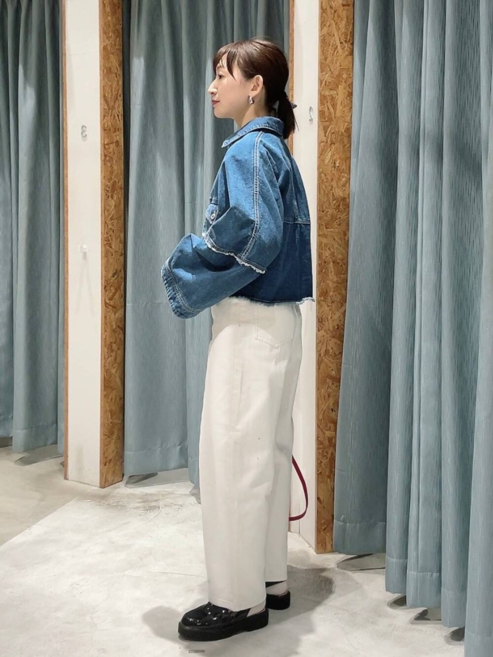 ホワイト系のデニムパンツ、ブラック系のローファー、ブルー系のデニムジャケットを着用したレディースの冬コーディネートの4枚目の写真