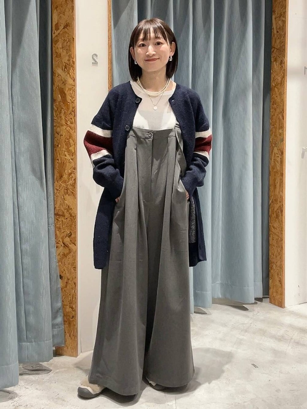 グレー系のその他パンツ、ベージュ系のその他シューズ、ブルー系のチュニックを着用したレディースの冬コーディネートの6枚目の写真