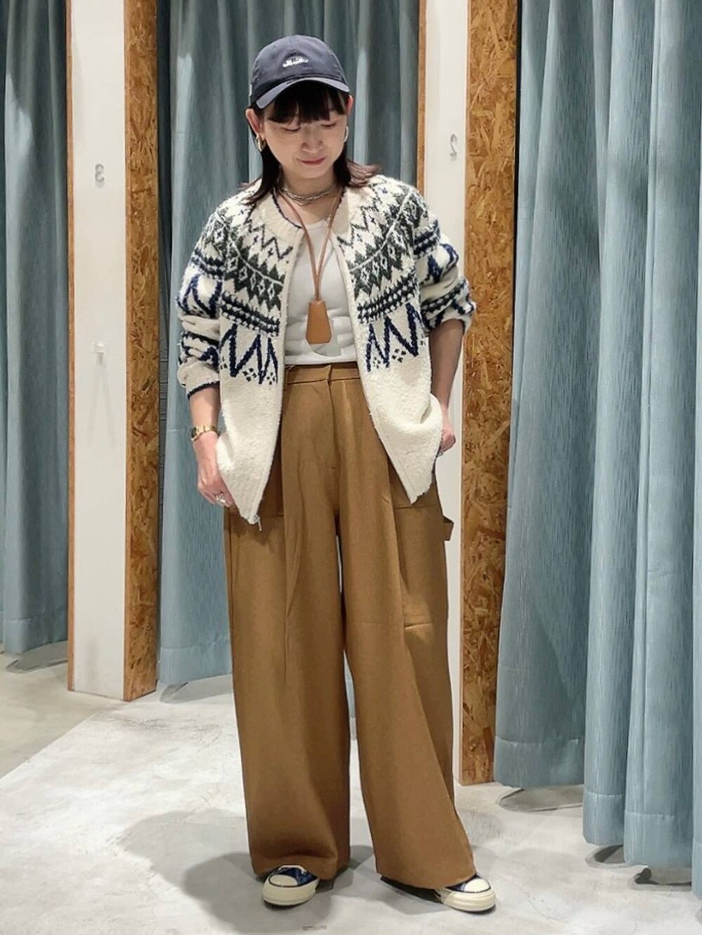 ブルー系のスニーカー、ホワイト系のカーディガン/ボレロ、ブルー系のキャップを着用したレディースの秋コーディネートの4枚目の写真