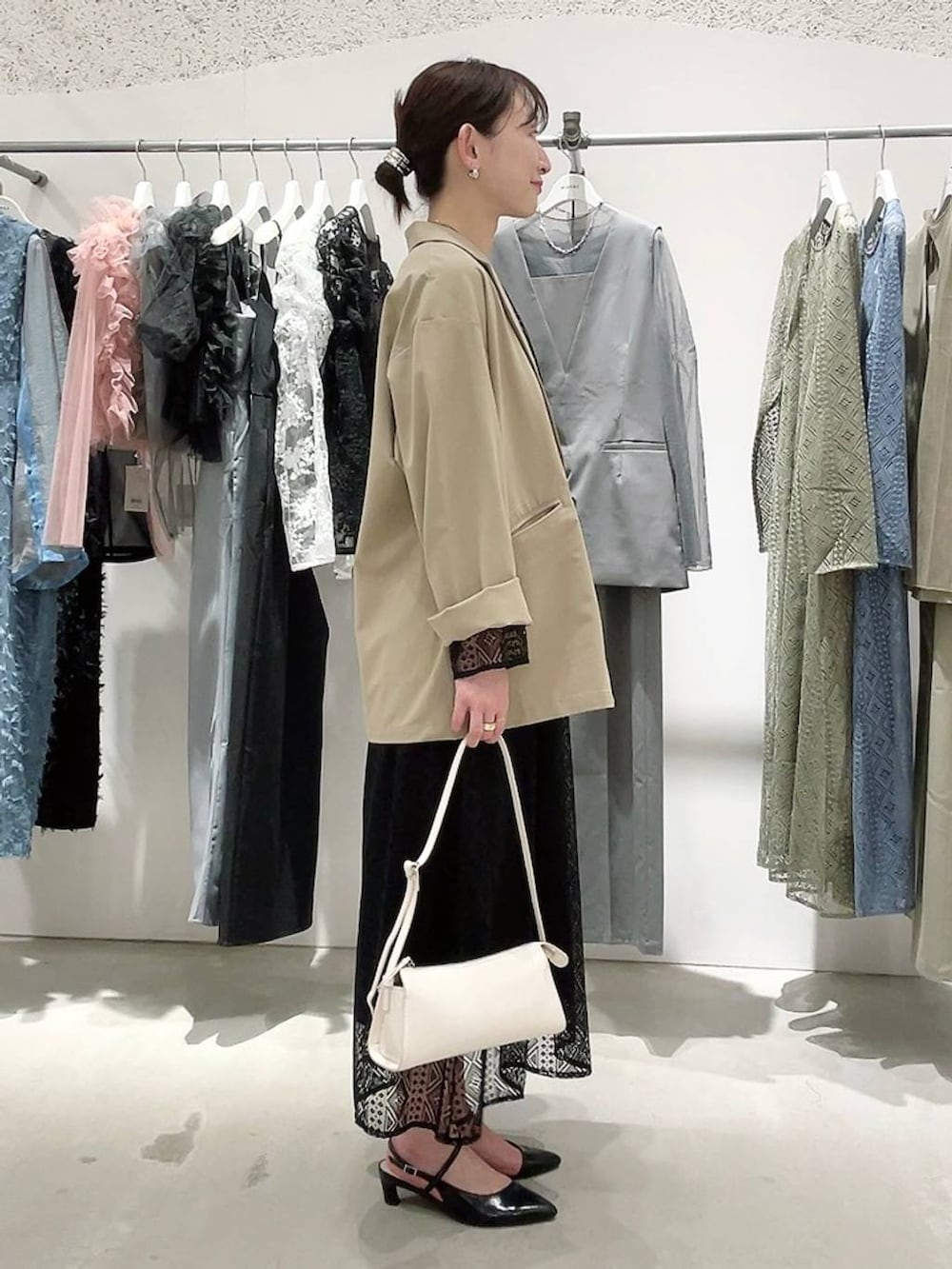 ベージュ系のテーラードジャケット、ブラック系のドレス、ゴールド系のネックレスを着用したレディースの春コーディネートの3枚目の写真