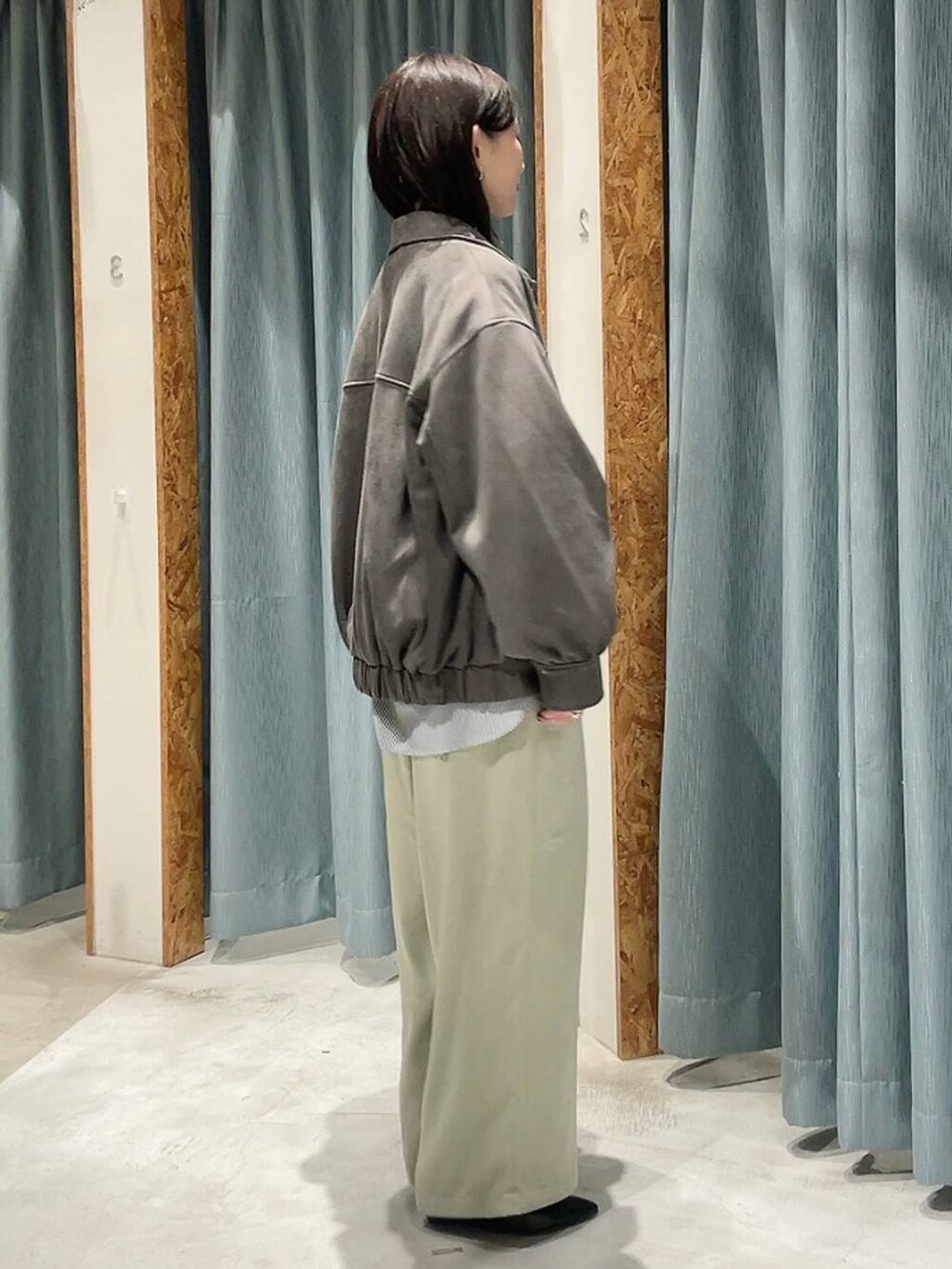 グレー系のシャツ/ブラウス、ブラック系のパンプス、グリーン系のその他パンツを着用したレディースの秋コーディネートの6枚目の写真
