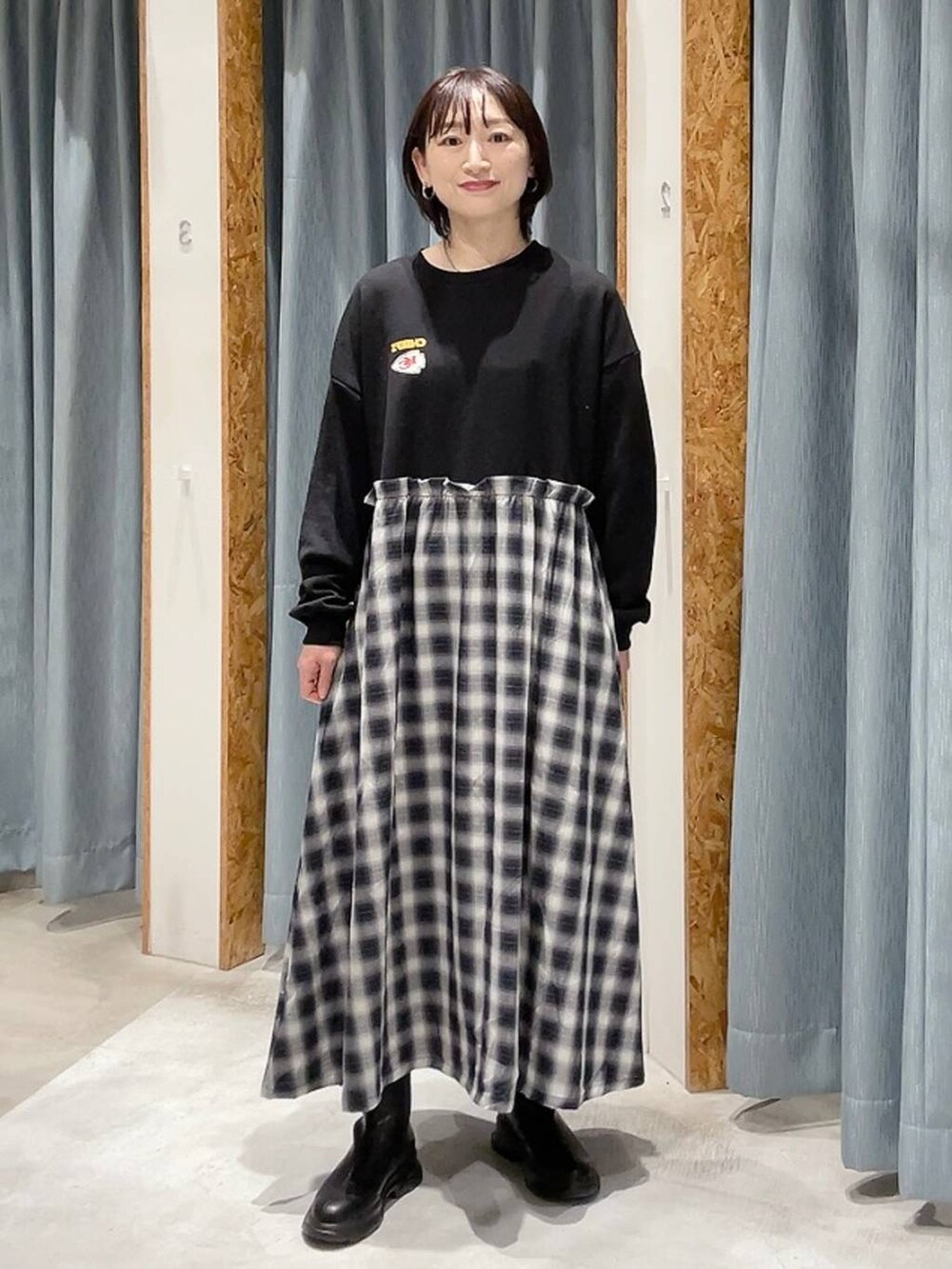 ブラック系のブーツ、ブラック系のワンピースを着用したレディースの秋コーディネートの4枚目の写真