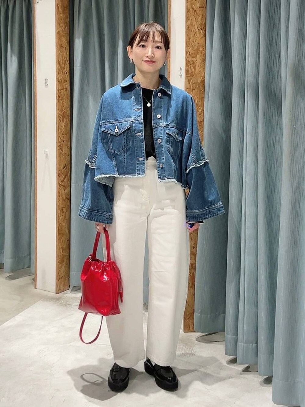 ホワイト系のデニムパンツ、ブラック系のローファー、ブルー系のデニムジャケットを着用したレディースの冬コーディネートの5枚目の写真