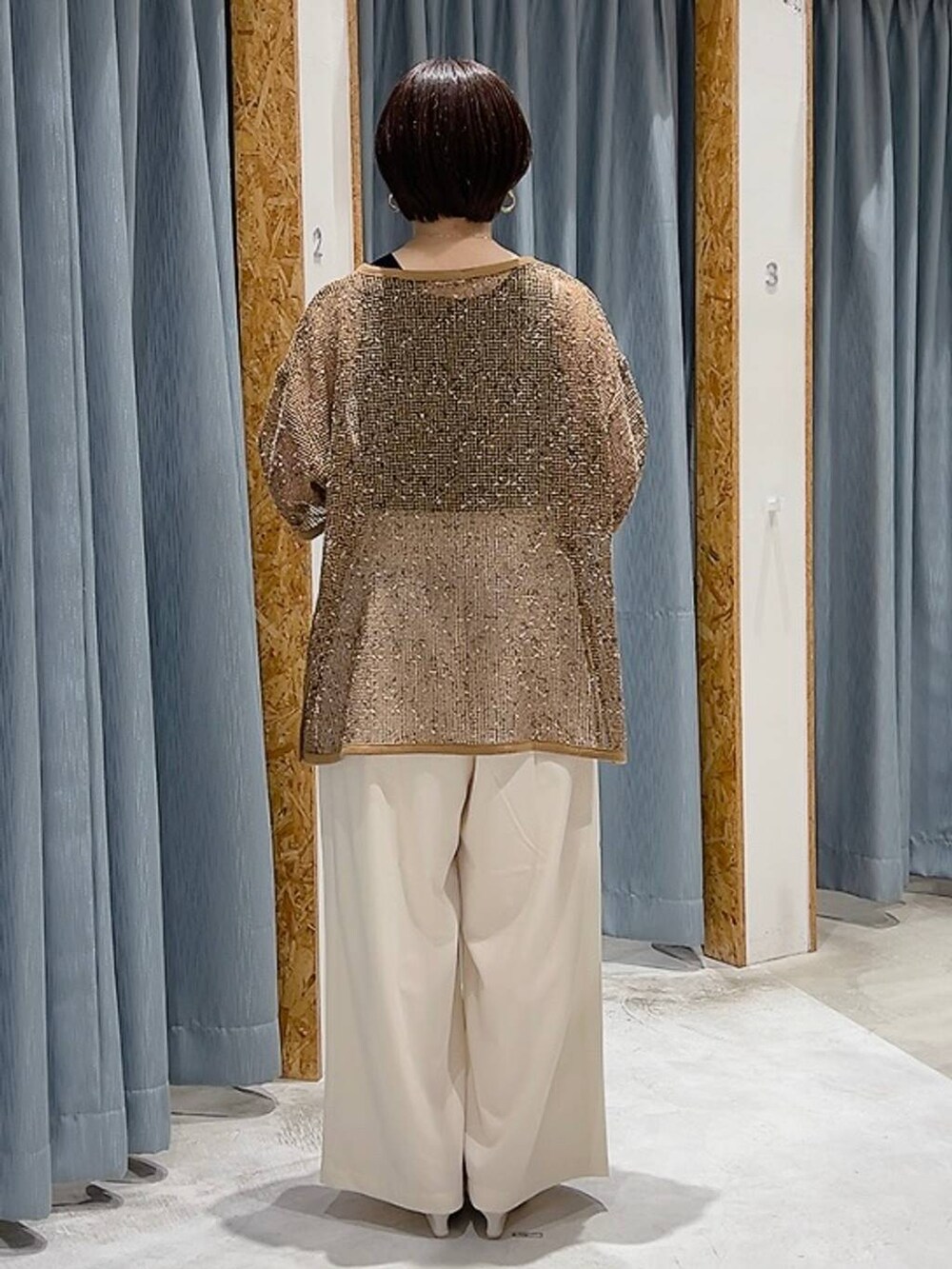 ホワイト系のサンダル、ブラック系のタンクトップ、ホワイト系のスラックスを着用したレディースの夏コーディネートの3枚目の写真