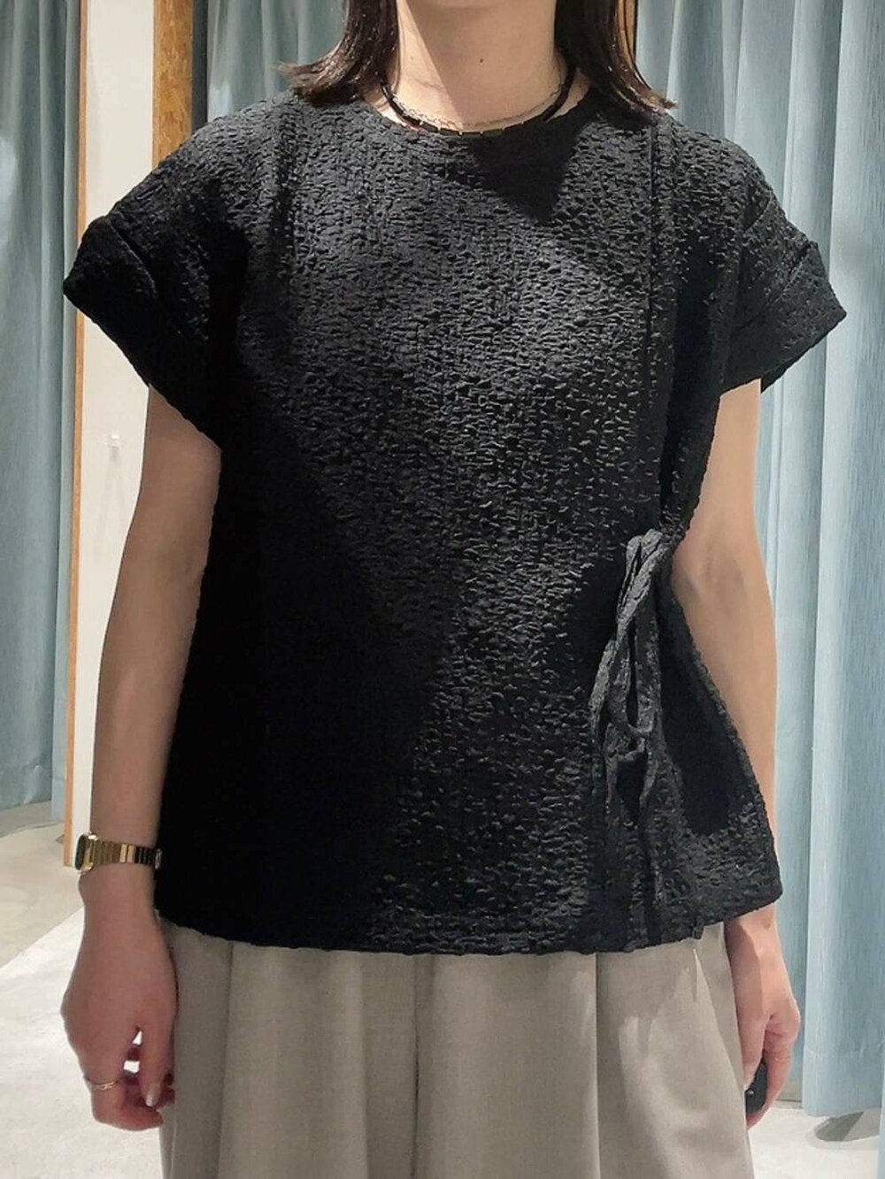 ブラウン系のサンダル、ベージュ系のその他パンツ、ブラック系のTシャツ/カットソーを着用したレディースの夏コーディネートの2枚目の写真