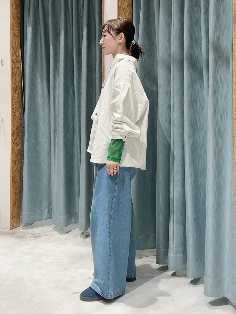 ブルー系のスニーカー、ブラック系のTシャツ/カットソー、ブルー系のデニムパンツを着用したレディースの冬コーディネートの4枚目の写真