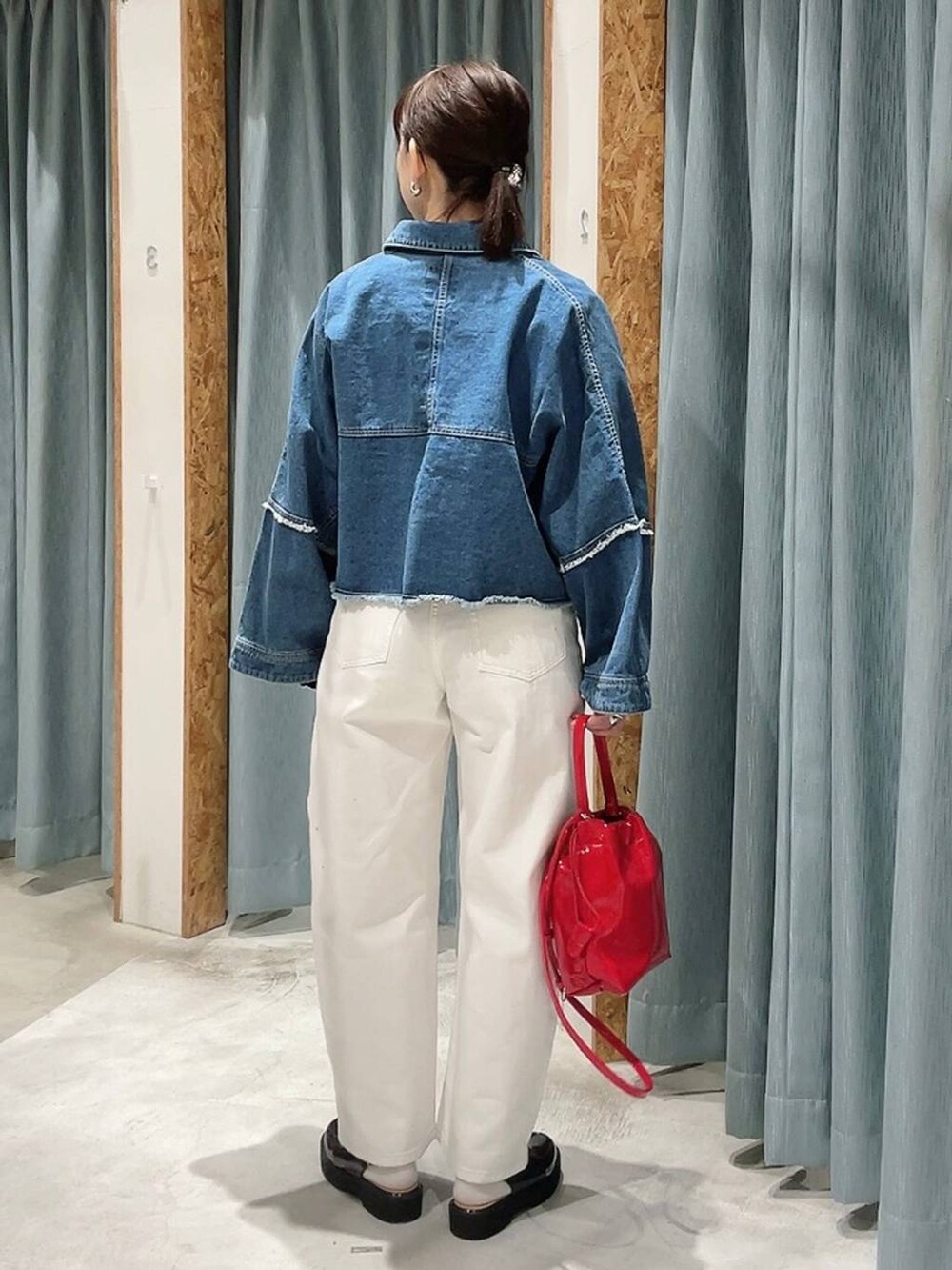 ホワイト系のデニムパンツ、ブラック系のローファー、ブルー系のデニムジャケットを着用したレディースの冬コーディネートの3枚目の写真