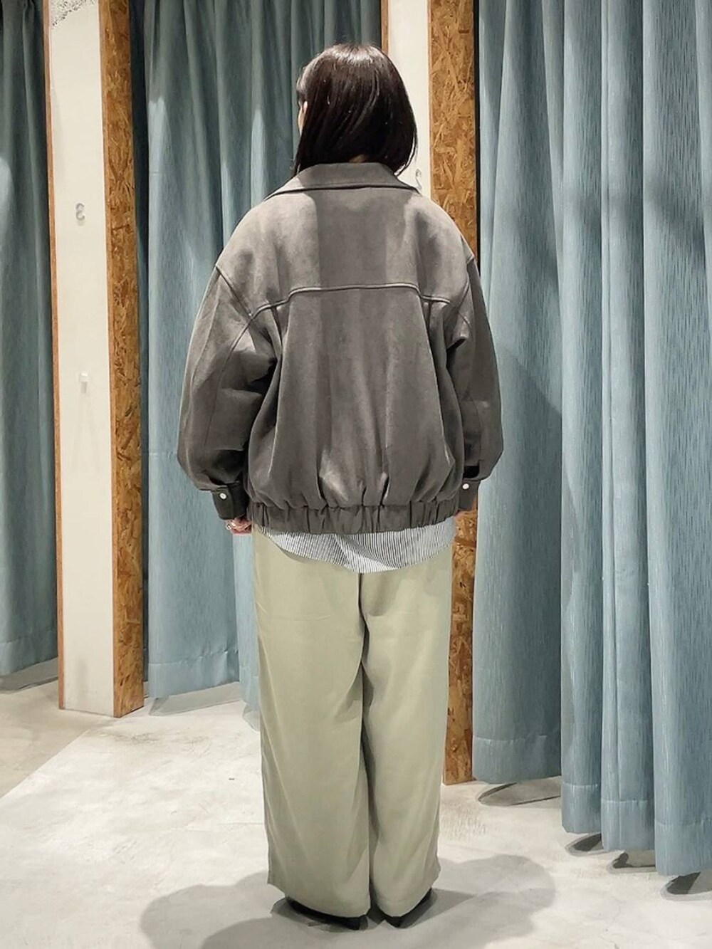 グレー系のシャツ/ブラウス、ブラック系のパンプス、グリーン系のその他パンツを着用したレディースの秋コーディネートの7枚目の写真