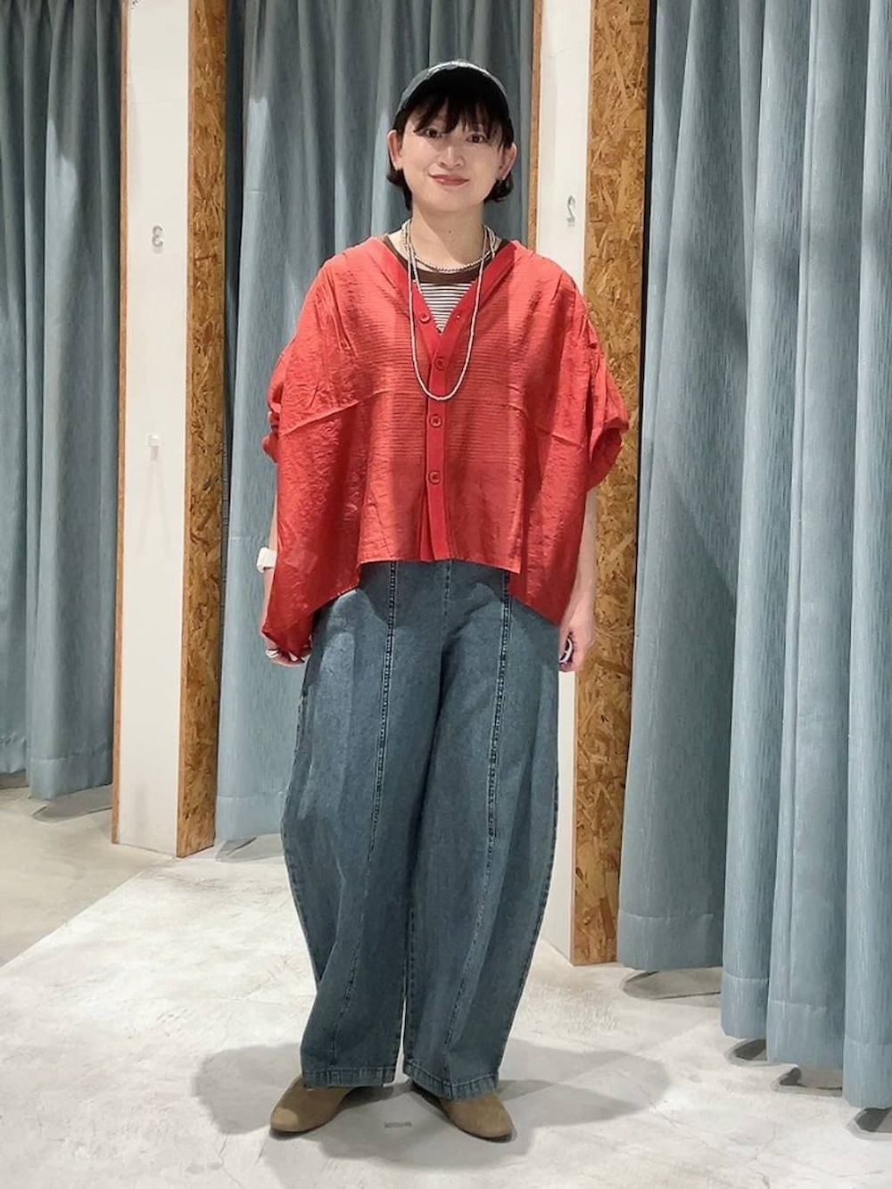 レッド系のシャツ/ブラウス、ベージュ系のパンプス、ブルー系のデニムパンツを着用したレディースの春コーディネートの2枚目の写真