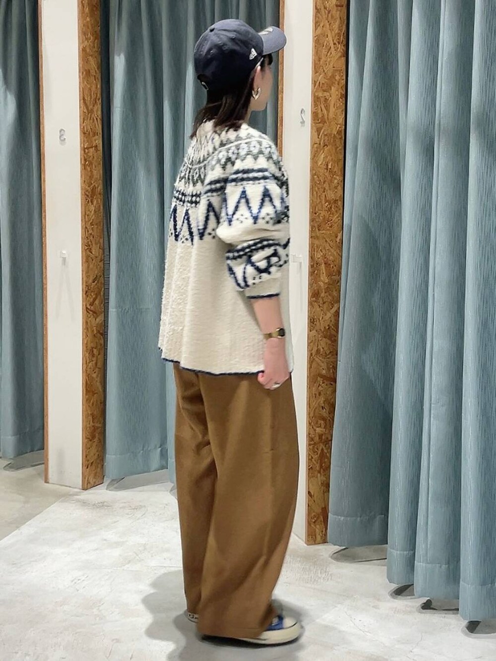 ブルー系のスニーカー、ホワイト系のカーディガン/ボレロ、ブルー系のキャップを着用したレディースの秋コーディネートの5枚目の写真