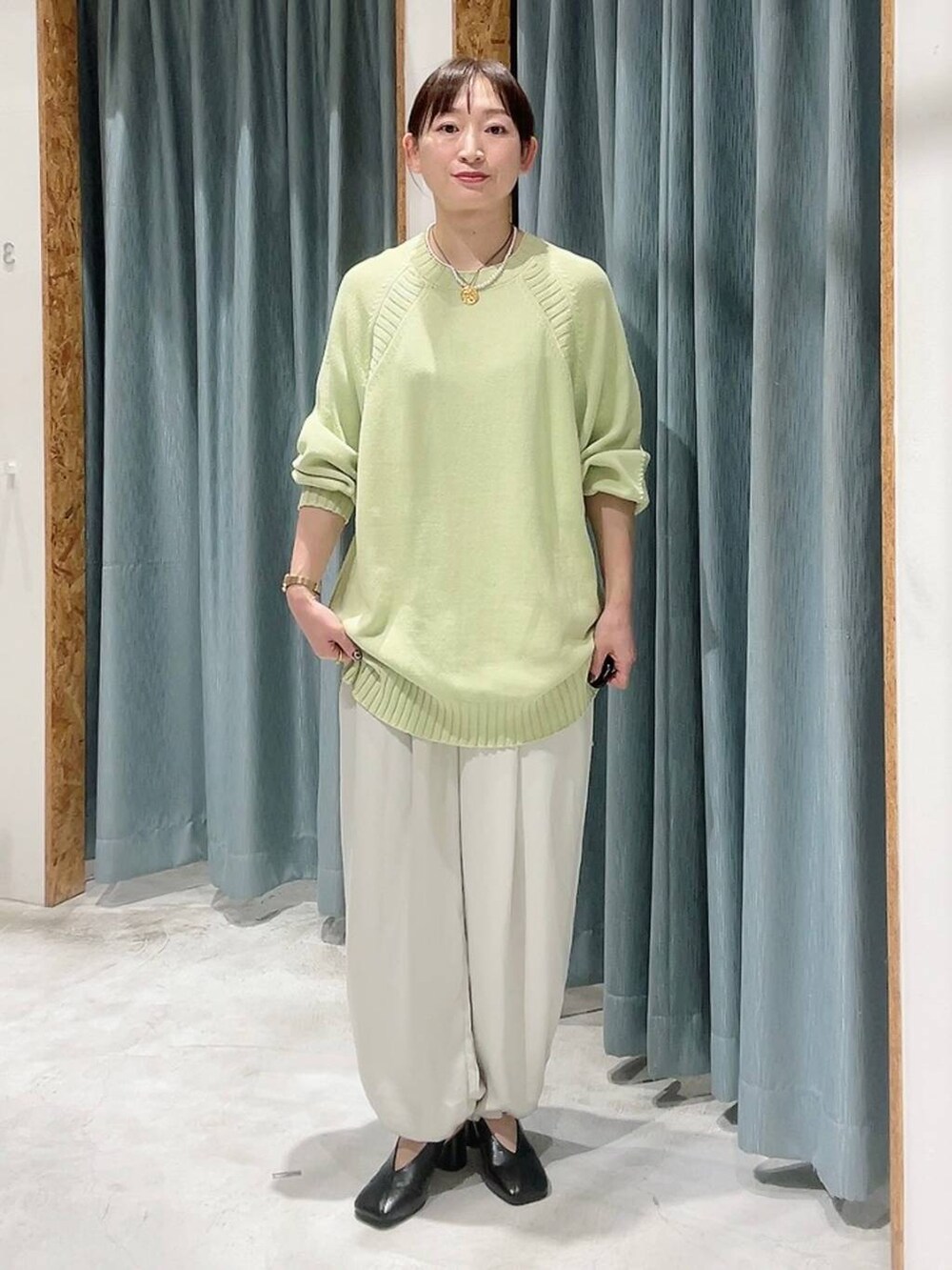 ホワイト系のその他パンツ、ブラック系のパンプス、グリーン系のニット/セーターを着用したレディースの冬コーディネートの6枚目の写真