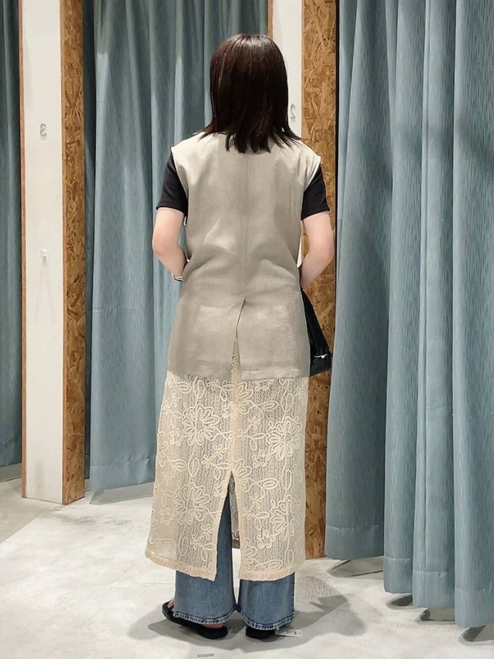 ブラック系のTシャツ/カットソー、ブラック系のハンドバッグ、ブラウン系のサンダルを着用したレディースの春コーディネートの5枚目の写真