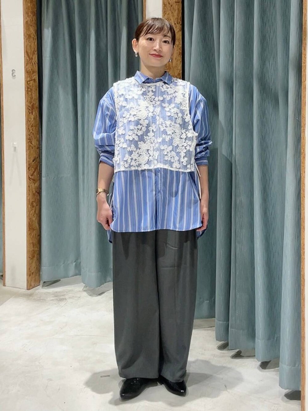 グレー系のその他パンツ、ブラック系のパンプス、ブルー系のシャツ/ブラウスを着用したレディースの冬コーディネートの2枚目の写真