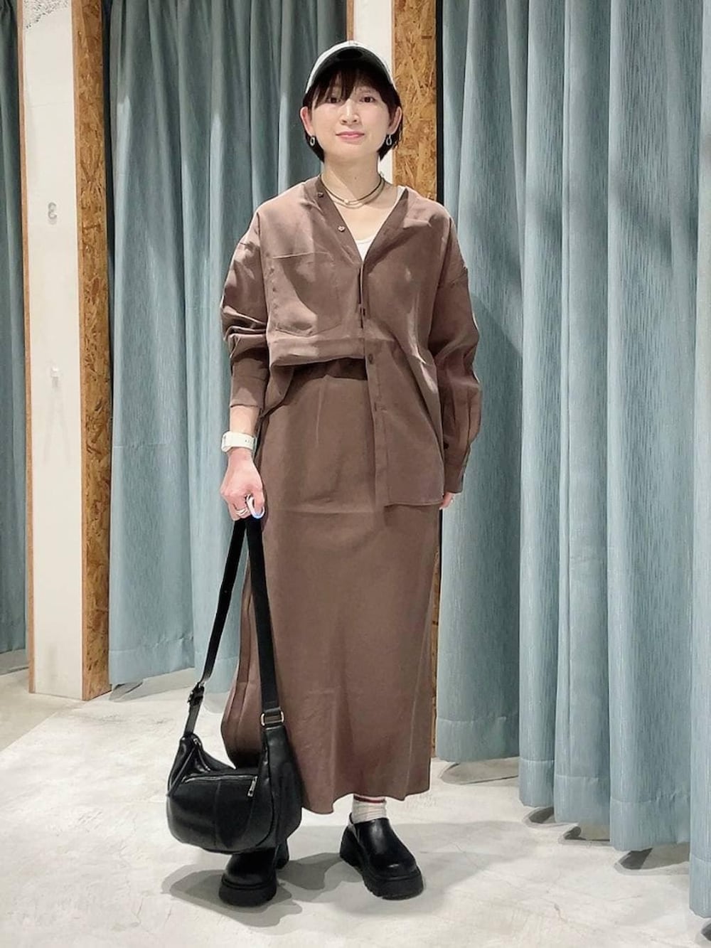 ブラック系のショルダーバッグ、ブラック系のその他シューズ、ブラウン系のシャツ/ブラウスを着用したレディースの春コーディネートの5枚目の写真