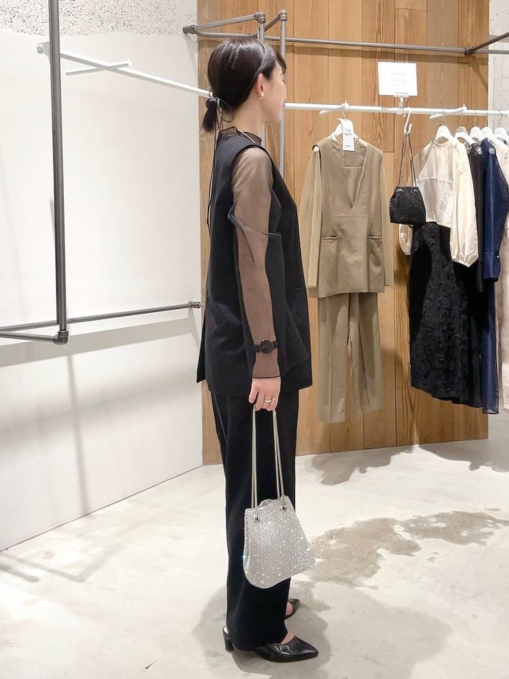 シルバー系のショルダーバッグ、ブラック系のパンプス、ブラック系のパンツドレスを着用したレディースの秋コーディネートの3枚目の写真