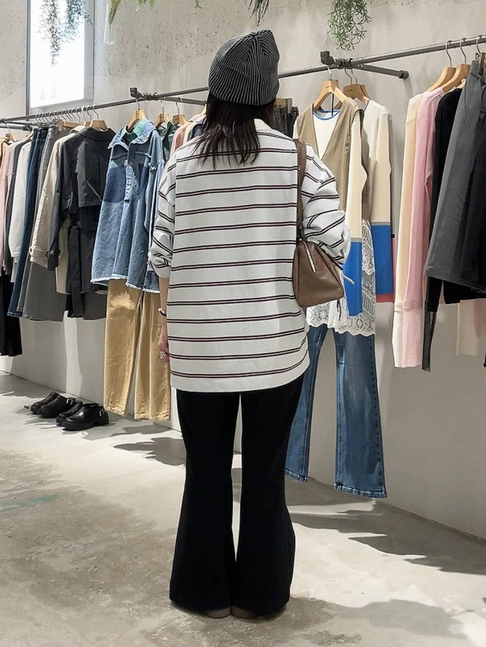 ブラウン系のボストンバッグ、ブラック系のスウェットパンツ、ブルー系のTシャツ/カットソーを着用したレディースの冬コーディネートの4枚目の写真