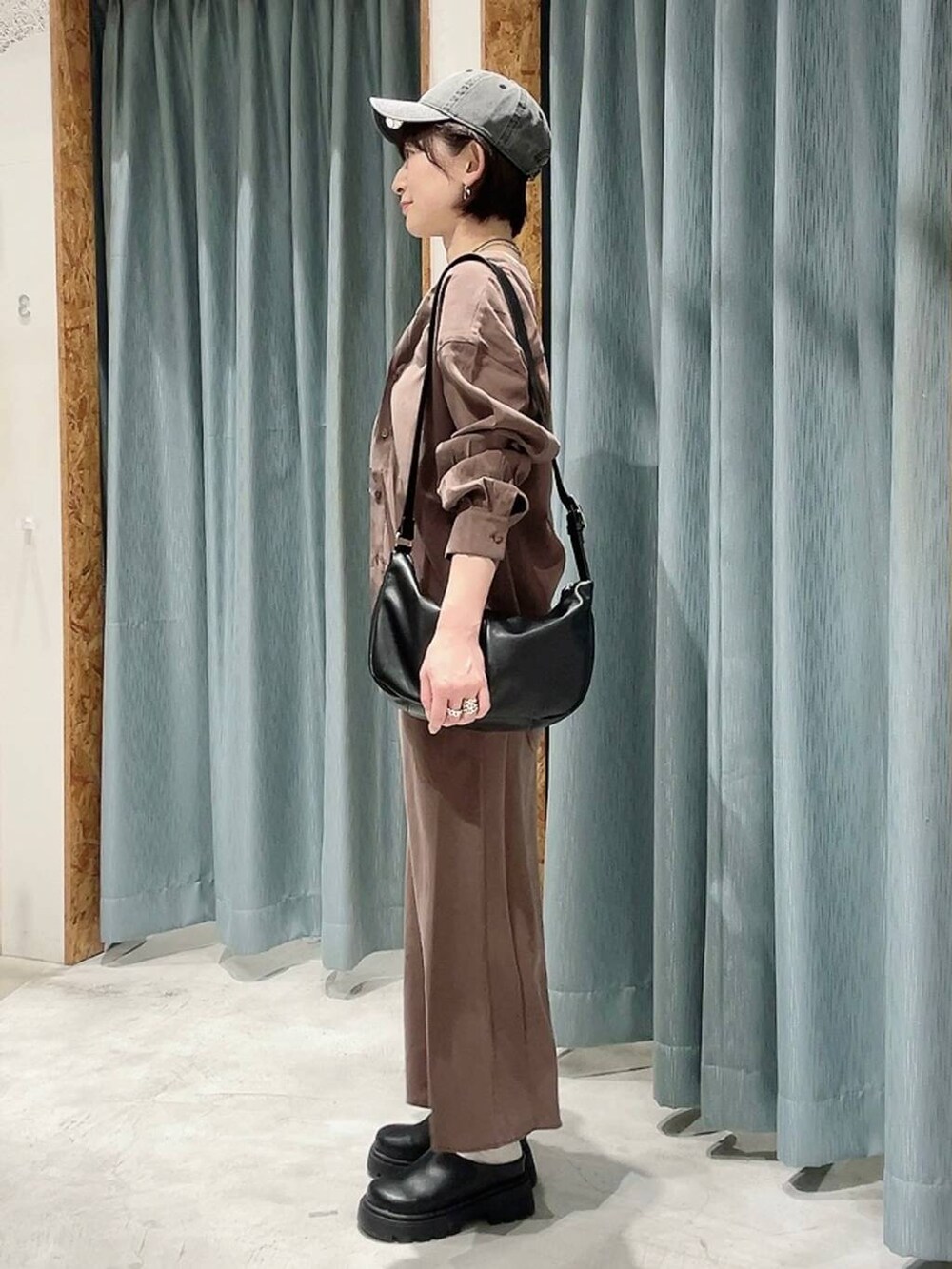 ブラック系のショルダーバッグ、ブラック系のその他シューズ、ブラウン系のシャツ/ブラウスを着用したレディースの春コーディネートの4枚目の写真