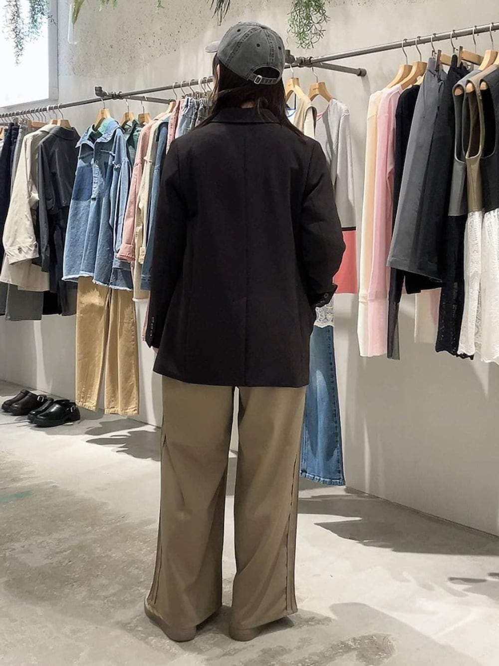 ブラック系のテーラードジャケット、ブラウン系のその他パンツ、ブラック系のキャップを着用したレディースの冬コーディネートの3枚目の写真