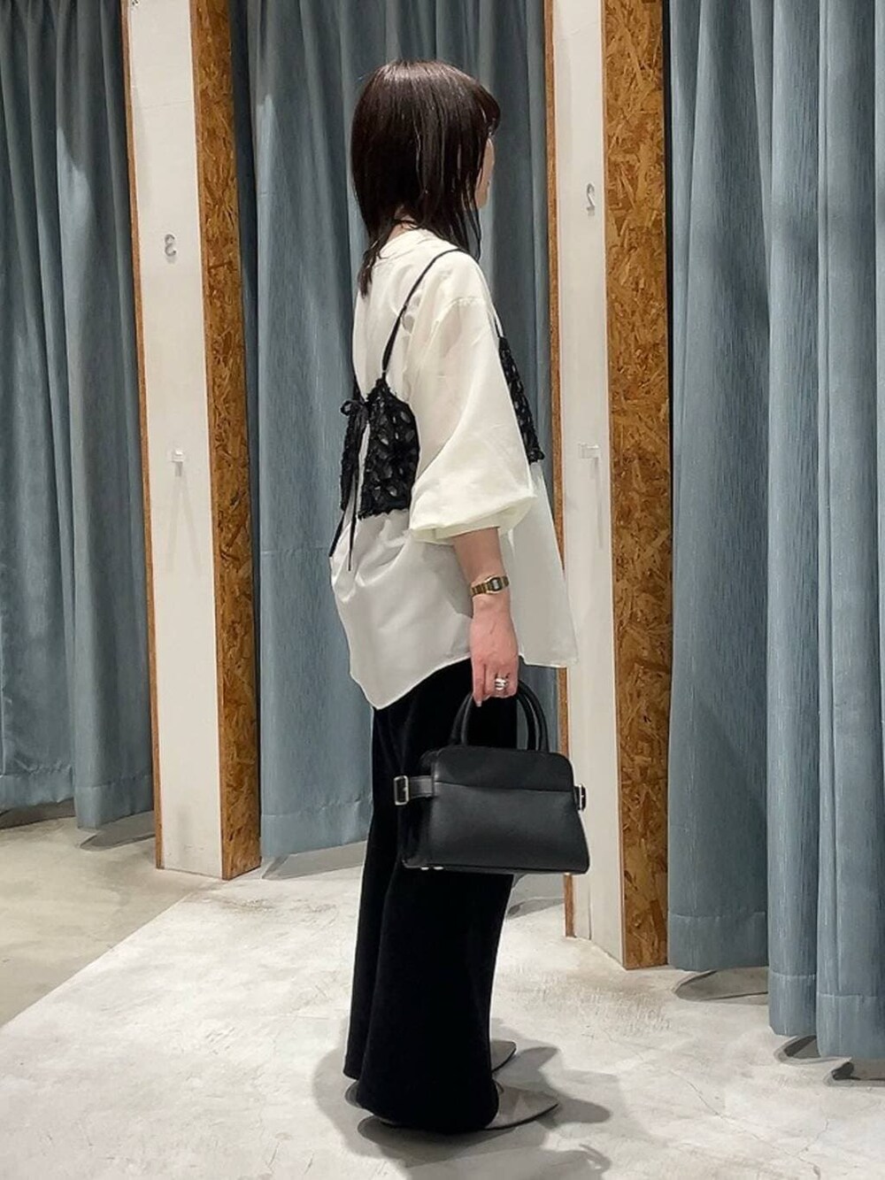 ブラック系のショルダーバッグ、シルバー系のパンプス、ホワイト系のシャツ/ブラウスを着用したレディースの冬コーディネートの2枚目の写真