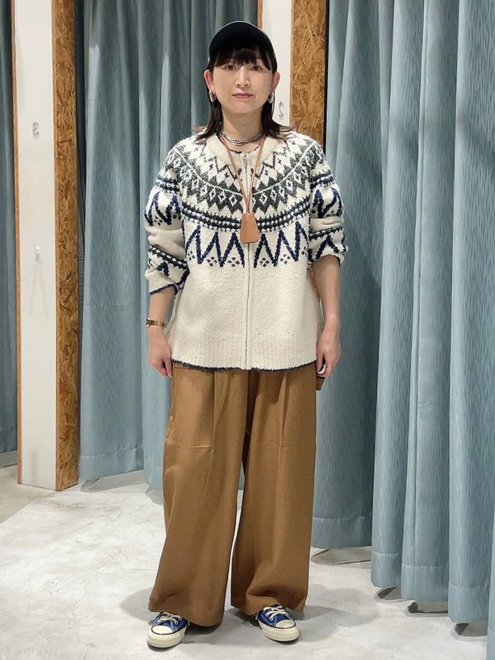 ブルー系のスニーカー、ホワイト系のカーディガン/ボレロ、ブルー系のキャップを着用したレディースの秋コーディネートの9枚目の写真