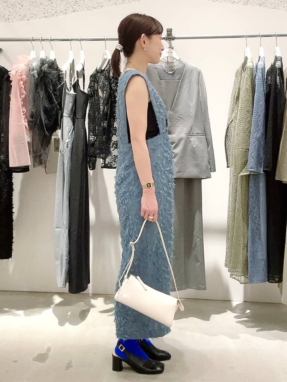 ホワイト系のショルダーバッグ、ブラック系のパンプス、ブラック系のキャミソールを着用したレディースの春コーディネートの4枚目の写真