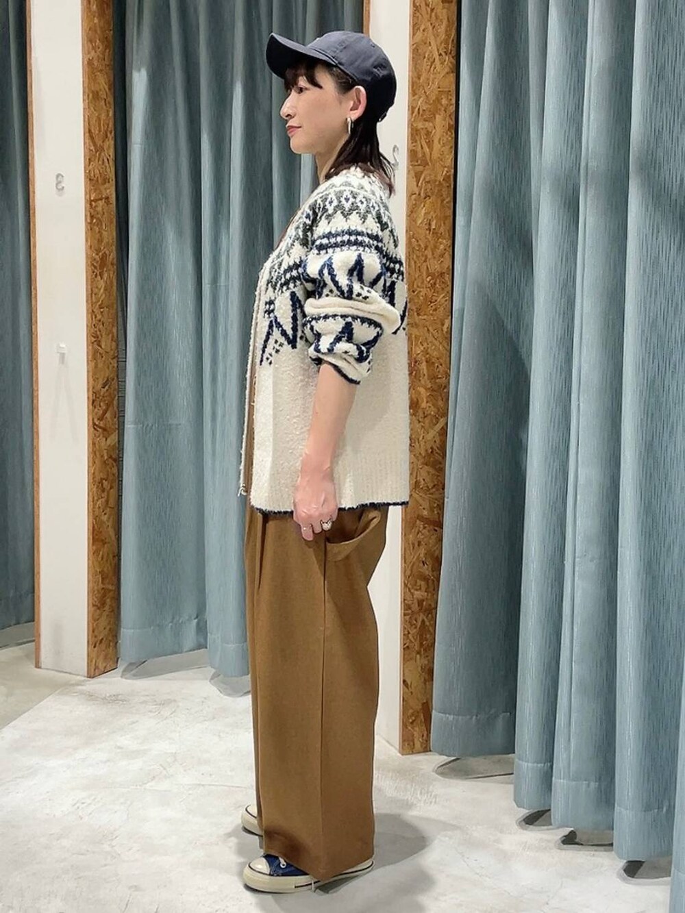 ブルー系のスニーカー、ホワイト系のカーディガン/ボレロ、ブルー系のキャップを着用したレディースの秋コーディネートの7枚目の写真