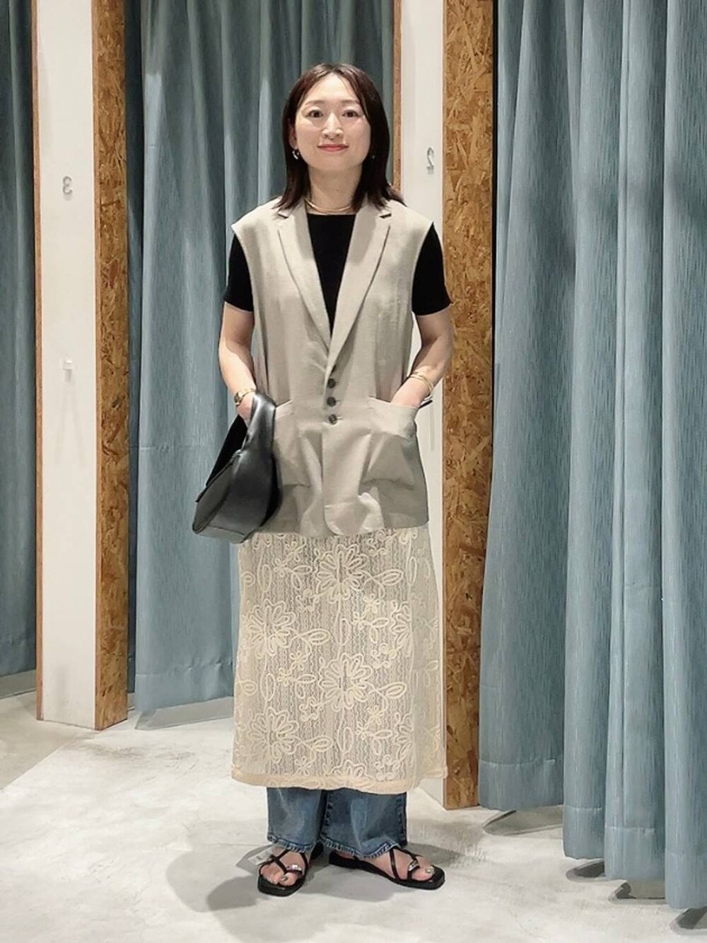 ブラック系のTシャツ/カットソー、ブラック系のハンドバッグ、ブラウン系のサンダルを着用したレディースの春コーディネートの3枚目の写真