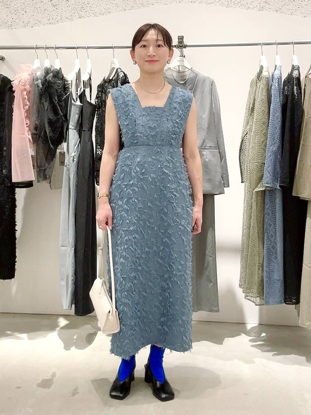 ホワイト系のショルダーバッグ、ブラック系のパンプス、ブラック系のキャミソールを着用したレディースの春コーディネートの3枚目の写真