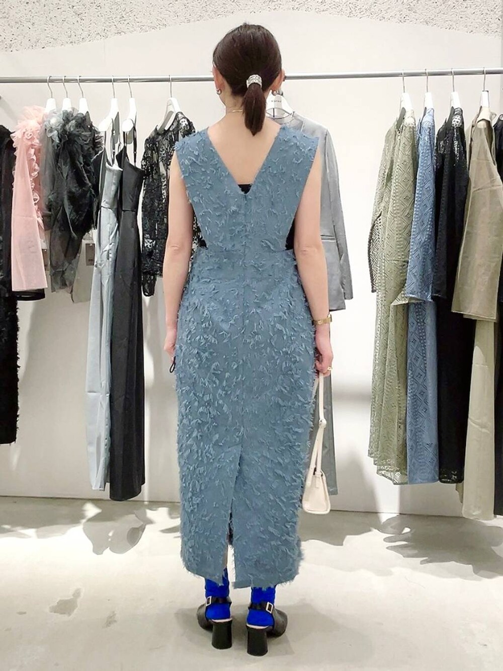 ホワイト系のショルダーバッグ、ブラック系のパンプス、ブラック系のキャミソールを着用したレディースの春コーディネートの5枚目の写真