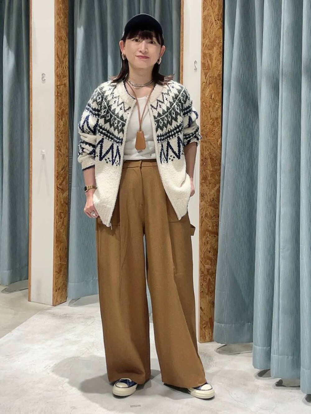 ブルー系のスニーカー、ホワイト系のカーディガン/ボレロ、ブルー系のキャップを着用したレディースの秋コーディネートの8枚目の写真