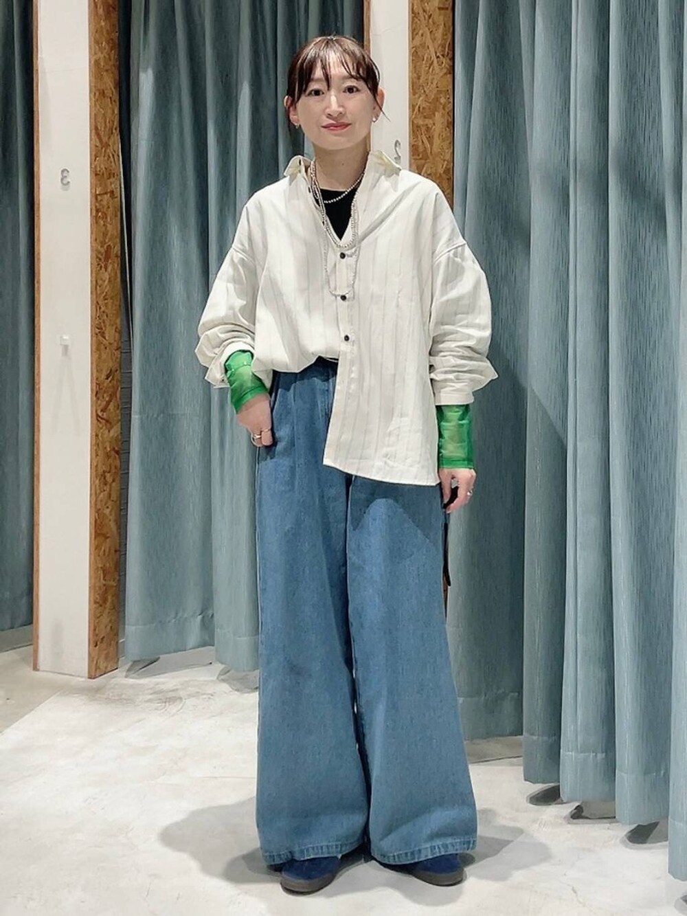 ブルー系のスニーカー、ブラック系のTシャツ/カットソー、ブルー系のデニムパンツを着用したレディースの冬コーディネートの5枚目の写真