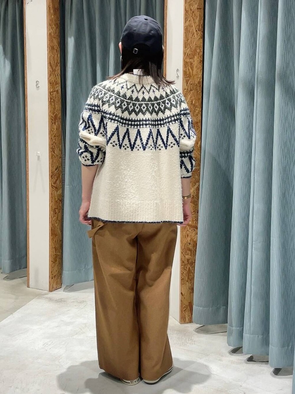 ブルー系のスニーカー、ホワイト系のカーディガン/ボレロ、ブルー系のキャップを着用したレディースの秋コーディネートの6枚目の写真