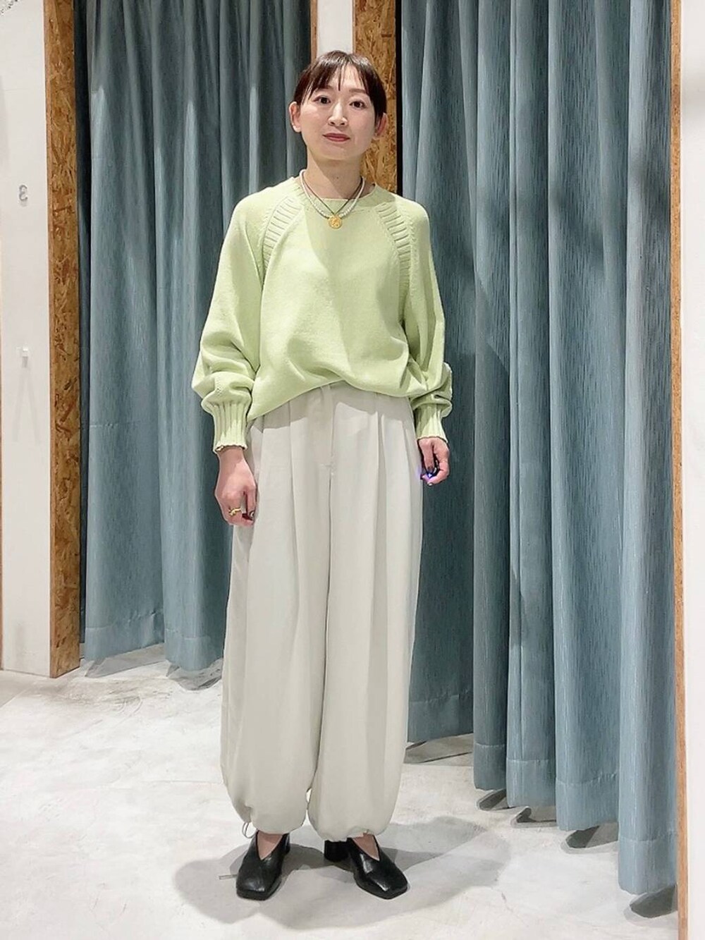 ホワイト系のその他パンツ、ブラック系のパンプス、グリーン系のニット/セーターを着用したレディースの冬コーディネートの5枚目の写真