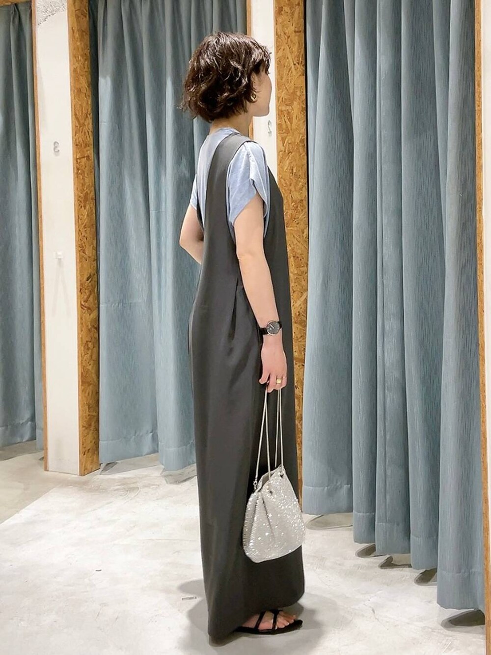 シルバー系のショルダーバッグ、ブラック系のサンダル、グレー系のサロペット/オーバーオールを着用したレディースの夏コーディネートの2枚目の写真