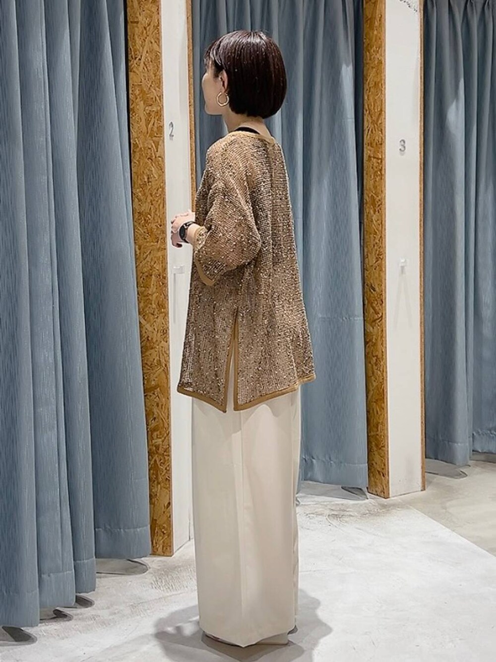 ホワイト系のサンダル、ブラック系のタンクトップ、ホワイト系のスラックスを着用したレディースの夏コーディネートの2枚目の写真