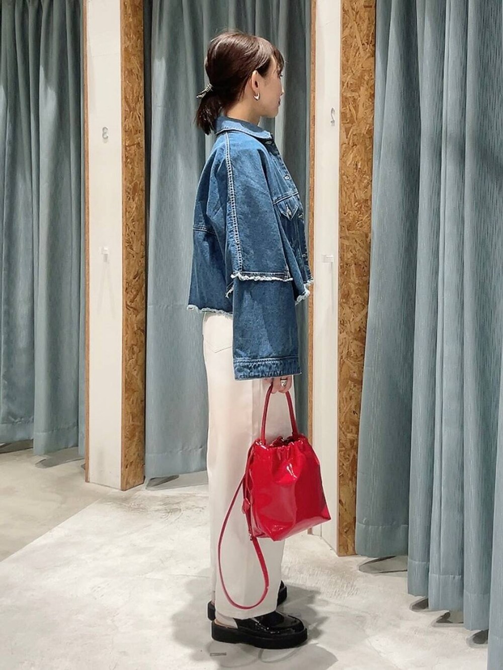 ホワイト系のデニムパンツ、ブラック系のローファー、ブルー系のデニムジャケットを着用したレディースの冬コーディネートの2枚目の写真